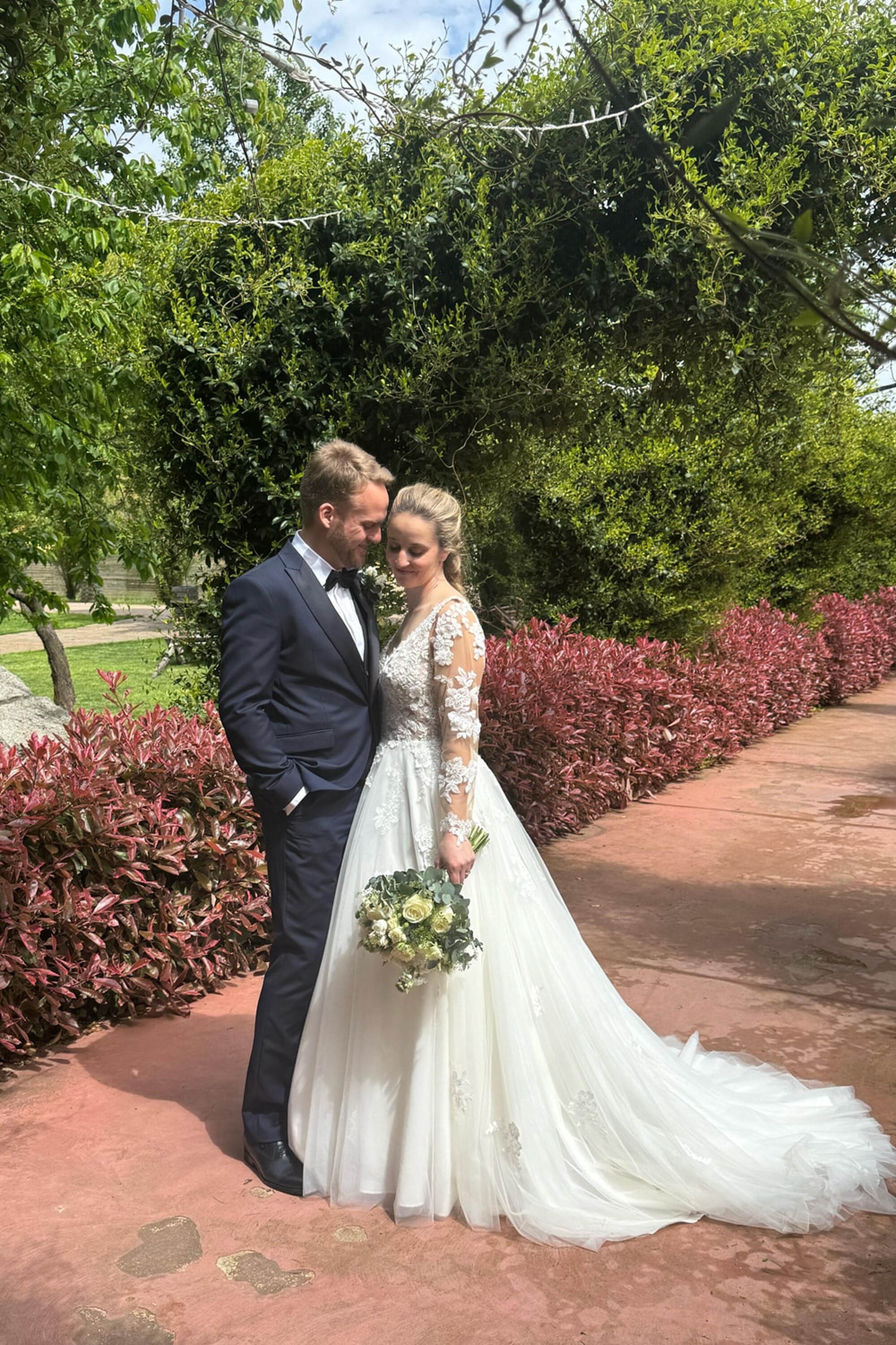 Coppia di sposi fotografati in un prato, abito Patrizia Cavalleri